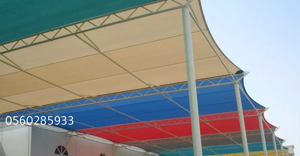 مظلة فاخرة معلقة فوق طاولة طعام خارجية مصممة لتحمل الرياح وتوفير الحماية.